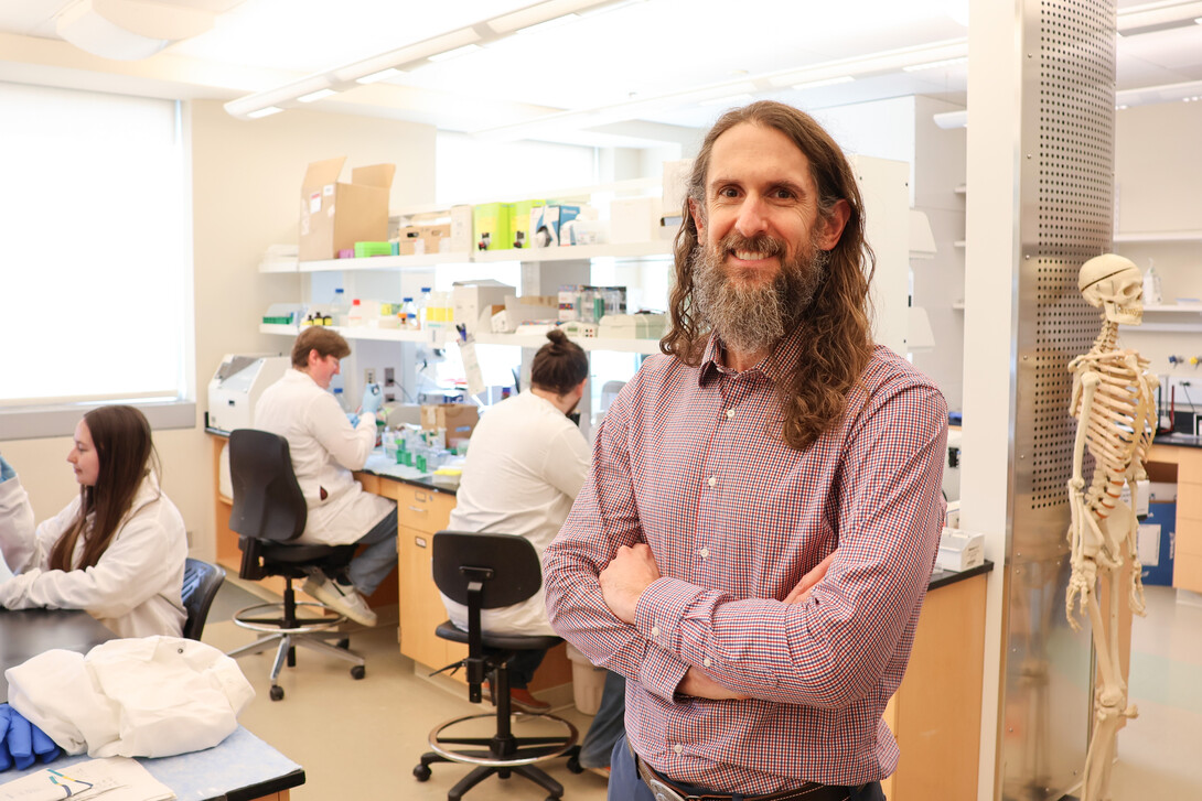 Forrest Kievit in his lab, with students working in the background.