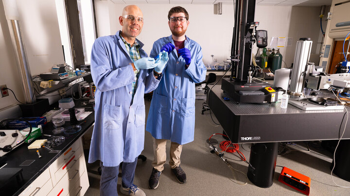 Stephen Morin, associate professor of chemistry, and Brennan Watts, a fourth-year doctoral student in chemistry, hold two colorful hydrogel skins that can act similarly to the color-changing skin of cephalopods such as octopi and cuttlefish. Their research article on the topic published in Advanced Materials in May.