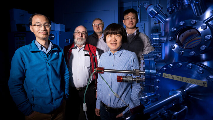 Husker physicists (from left) Xiaoshan Xu, Peter Dowben, Evgeny Tsymbal, Xia Hong and Zuocheng Zhang stand next to an oxide thin film deposition system inside Hong’s lab in Jorgensen Hall.
