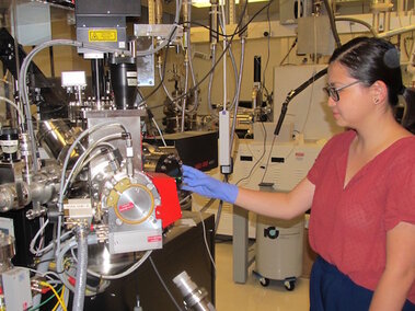 A high school intern conducts research in a lab